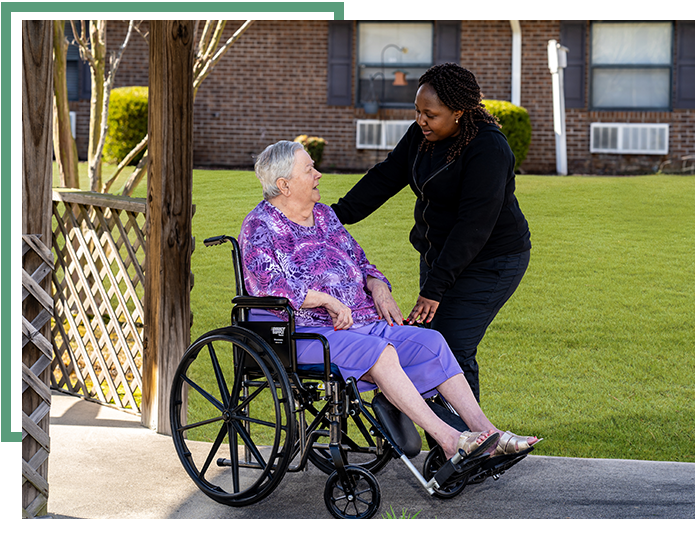 elderly patient sitting in a wheelchair with caregiver